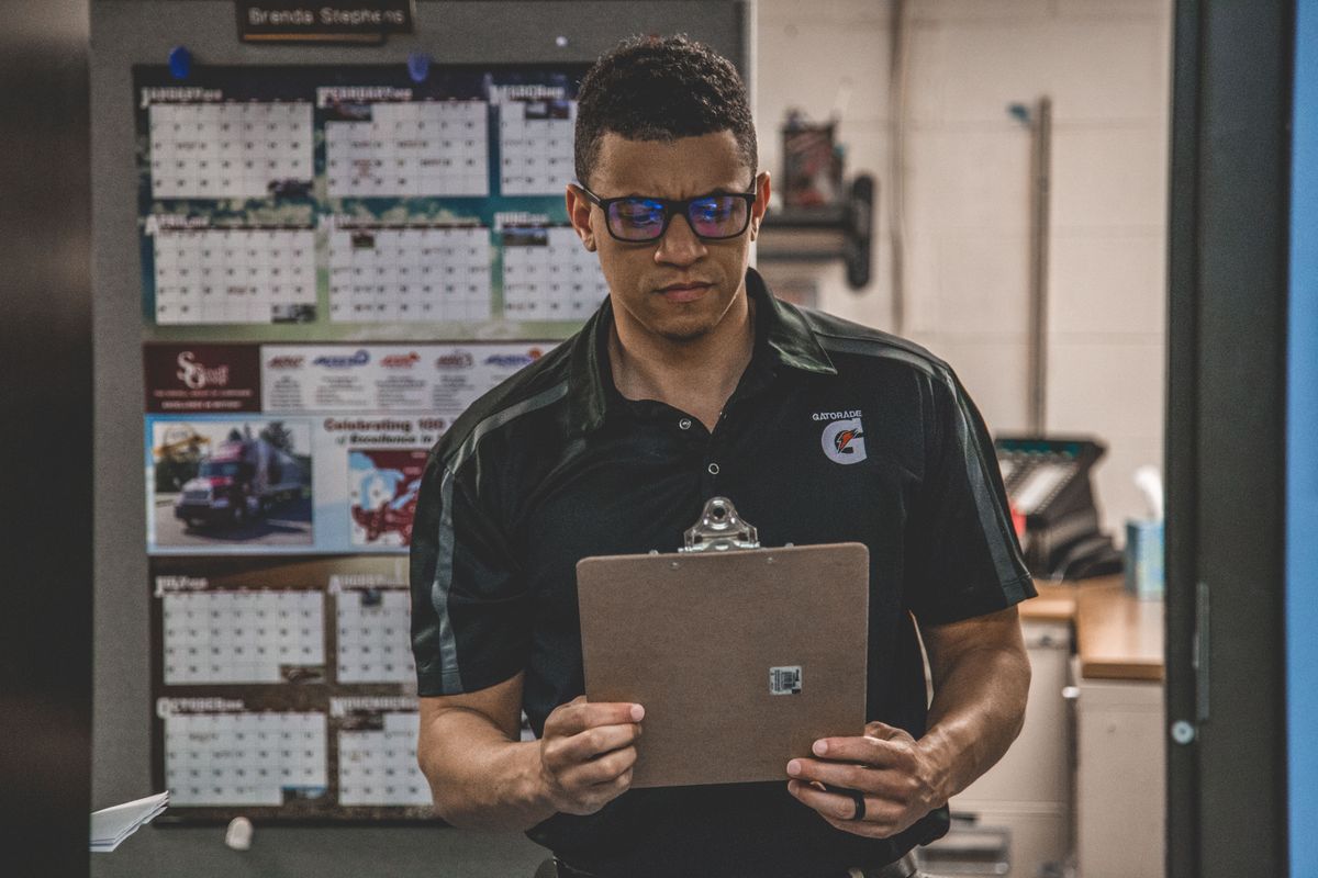 A serious worker in a warehouse checks documents