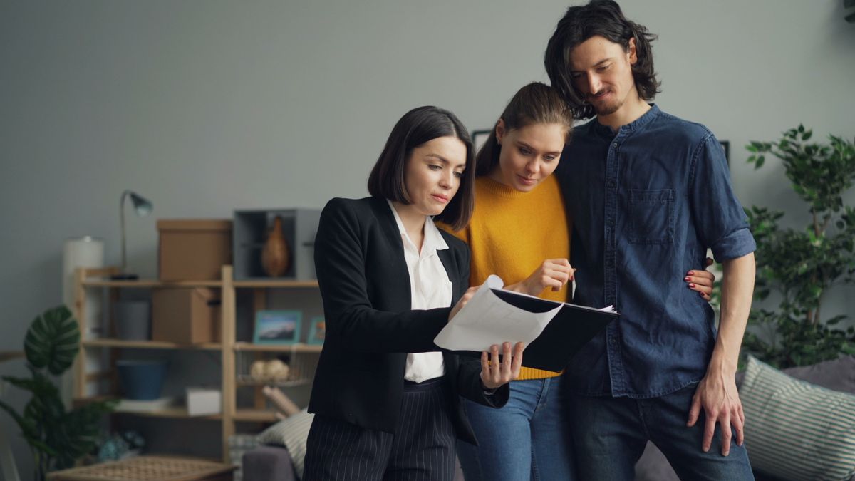 Young couple consulting with a real estate agent about property one indoors