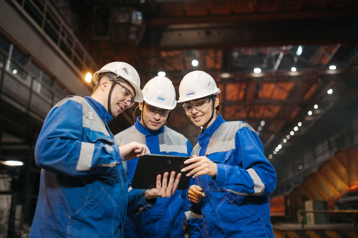 Group of engineers discussing project on a tablet in factory