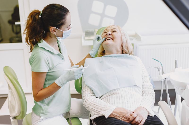 A female dentist examining a senior woman in a dental office
