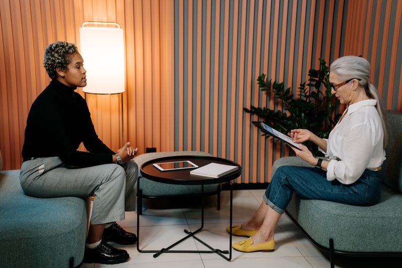 Two women in professional interview setting using a tablet