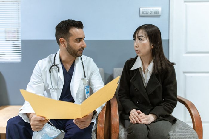Doctor discusses health records with a patient in a clinical setting