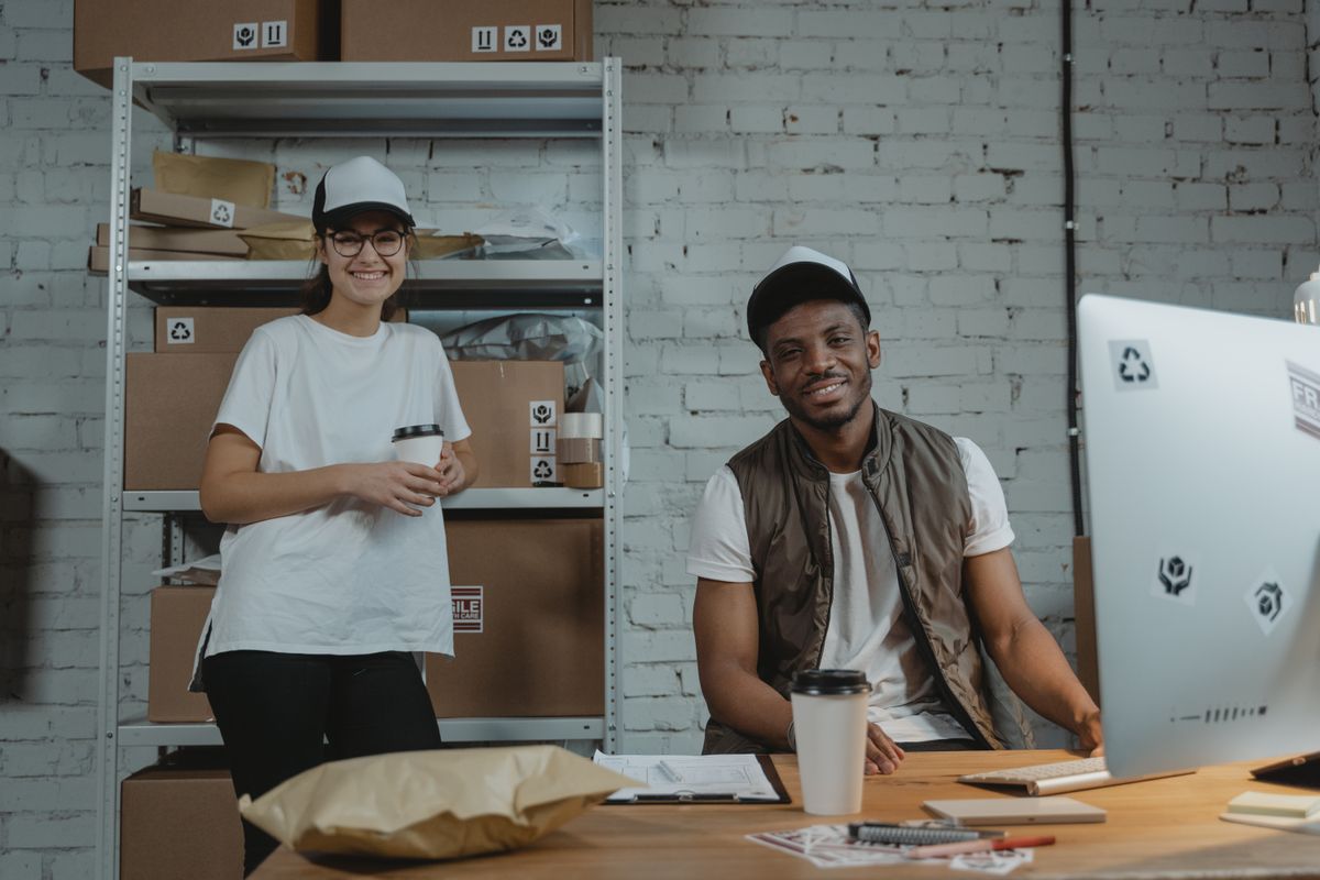 Two warehouse employees in casual attire smiling