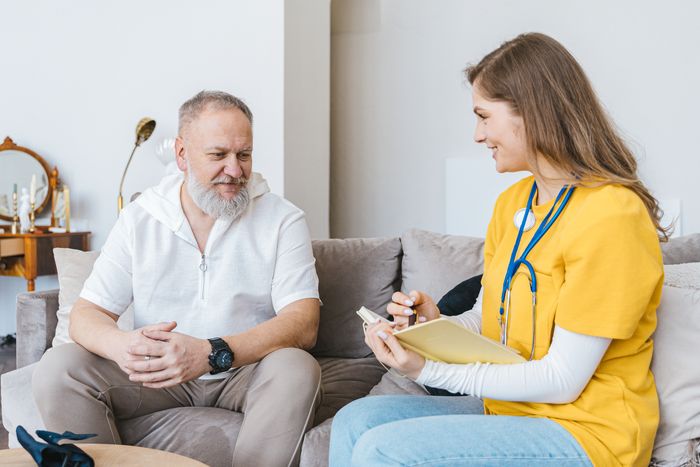 A healthcare professional consulting with an elderly man