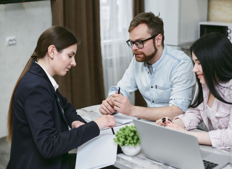 A couple discusses financial documents with their advisor
