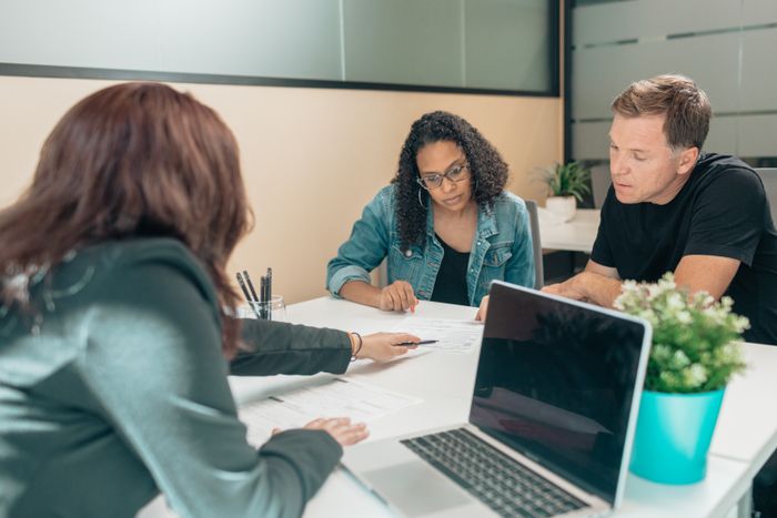Couple meeting with advisor for adoption process in a modern office setting