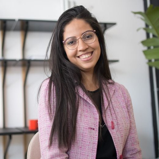 Smiling woman in pink blazer with eyeglasses